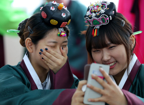 26일 오전 경기도 양평군 옥천면 양근향교에서 수능을 마친 양평고등학교 고3 여학생들이 성년식을 치르기 위해 한복을 착용한 후 휴대폰으로 자신들의 모습을 담으며 환하게 웃고 있다. 연합뉴스
