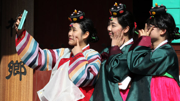 26일 오전 경기도 양평군 옥천면 양근향교에서 수능을 마친 양평고등학교 고3 여학생들이 성년식을 치르기 위해 한복을 착용한 후 휴대폰으로 자신들의 모습을 담으며 환하게 웃고 있다. 연합뉴스