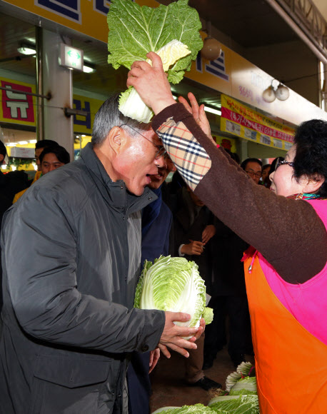 민주통합당 문재인 대선 후보가 29일 오전 여수 서교동 서시장을 방문, 야채가게 곽초자 여사가 배춧잎을 머리에 씌어주자 웃음으로 화답하고 있다. 연합뉴스