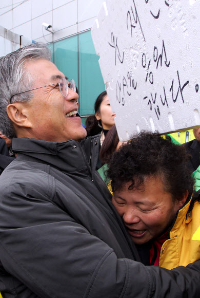 민주통합당 문재인 대선 후보가 29일 오전 전남 여수시 서교동 서시장을 방문, 문 후보를 지지하는 글이 적힌 스티로폼 박스를 든 상인과 포옹을 하고 있다.  연합뉴스