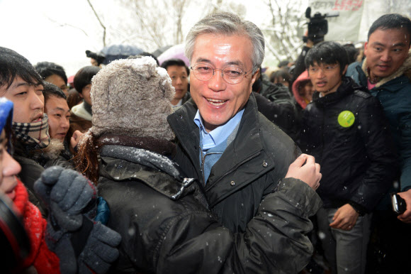 민주통합당 문재인 대선후보가 폭설이 내린 5일 서울시 동대문구 전농동 서울시립대에서 대학생과 포옹하고 있다.  연합뉴스