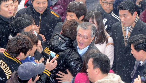 민주통합당 문재인 대선후보가 폭설이 내린 5일 서울시 동대문구 전농동 서울시립대에서 대학생과 포옹하고 있다. 연합뉴스