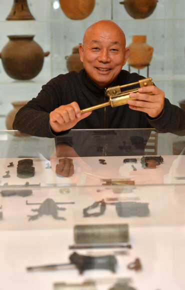 지난 2일 오후 서울 종로구 동숭동 쇳대박물관에서 만난 최홍규 관장이 전통적인 철물 디자인 역사를 얘기하면서 자물쇠와 열쇠를 들고 잠시 웃고 있다.  손형준기자 boltagoo@seoul.co.kr