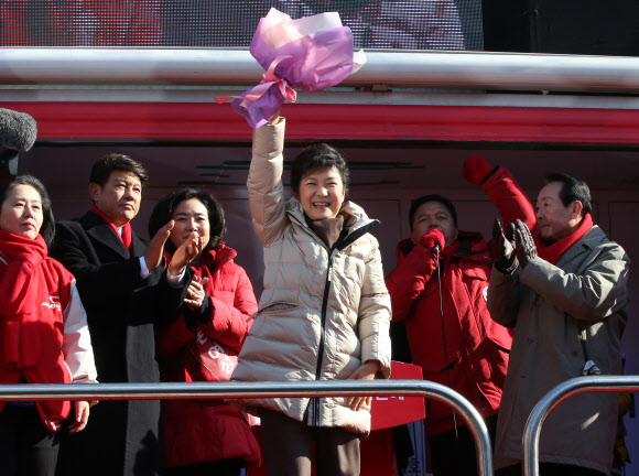 새누리당 박근혜 대선후보가 6일 오전 안산시 단원구 중앙역 유세에서 유권자들을 향해 선물 받은 꽃다발을 흔들고 있다.  연합뉴스