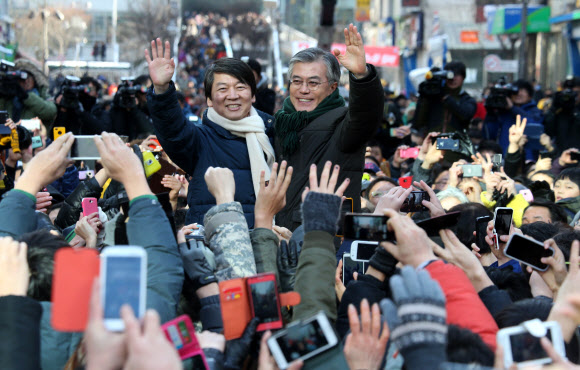 민주통합당 문재인 대선후보와 안철수 전 후보가 9일 경기도 군포시 산본역 앞에서 열린 집중유세에서 손을 들어 지지자들에게 답례하고 있다. 연합뉴스