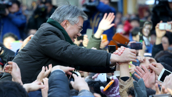 민주통합당 문재인 대선후보가 9일 경기도 군포시 산본역 앞에서 열린 집중유세에서 유권자의 손을 잡고 있다. 연합뉴스