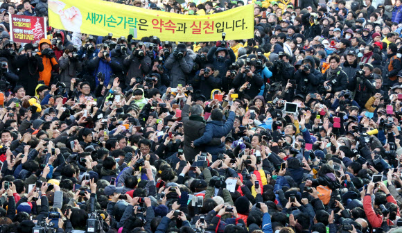 민주통합당 문재인 대선후보와 안철수 전 후보가 9일 경기도 군포시 산본역 앞에서 열린 집중유세에서 손을 들어 지지자들에게 답례하고 있다. 연합뉴스