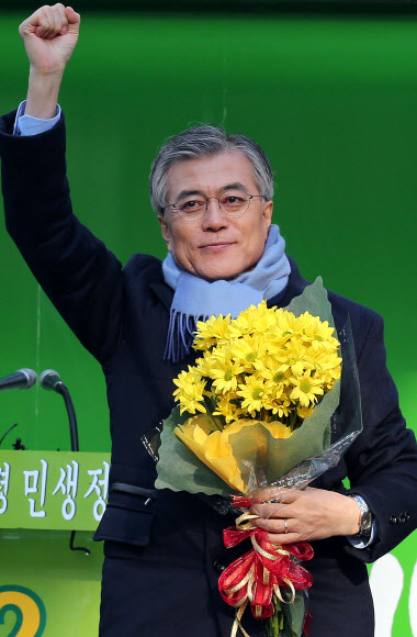 대선을 일주일 앞둔 12일 오후 민주통합당 문재인 대선후보가 12일 오후 청주 성안길 유세장에 입장해 손을 들어 인사하고 있다. 연합뉴스