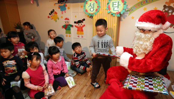 13일 오전 서울 은평구 배화유치원을 찾은 서울시 유아교육진흥원 ‘찾아가는 산타’가 어린이들에게 선물을 나눠 주고 있다. 연합뉴스