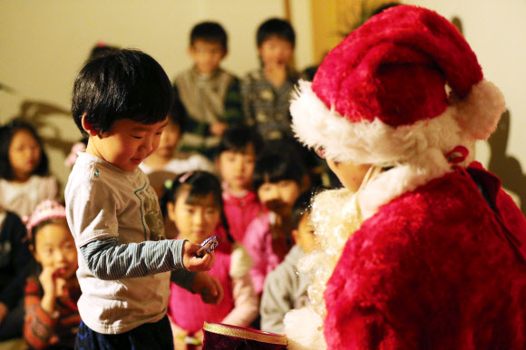 13일 오전 서울 은평구 배화유치원을 찾은 서울시 유아교육진흥원 ‘찾아가는 산타’가 어린이들에게 선물을 주고 있다. 연합뉴스
