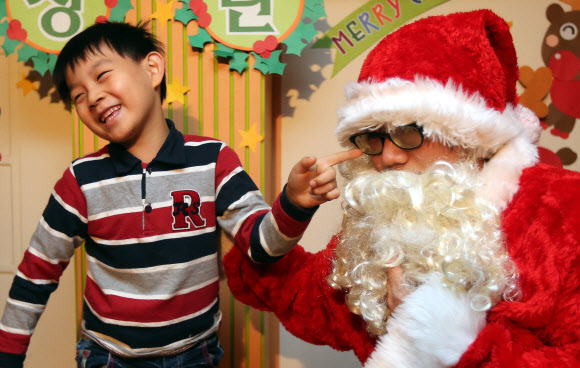 13일 오전 서울 은평구 배화유치원 어린이가 이곳을 방문한 서울시 유아교육진흥원 ‘찾아가는 산타’의 수염을 만져보고 있다. 연합뉴스