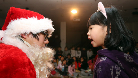 13일 오전 서울 은평구 배화유치원을 찾은 서울시 유아교육진흥원 ‘찾아가는 산타’가 어린이들에게 선물을 나눠 주고 있다. 연합뉴스