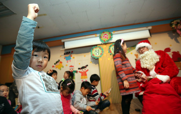 13일 오전 서울 은평구 배화유치원을 찾은 서울시 유아교육진흥원 ‘찾아가는 산타’가 어린이들에게 선물을 나눠 주고 있다. 연합뉴스