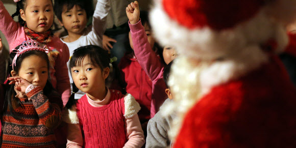 13일 오전 서울 은평구 배화유치원 어린이가 이곳을 찾은 서울시 유아교육진흥원 ‘찾아가는 산타’를 의심스러운 듯 바라보고 있다. 연합뉴스