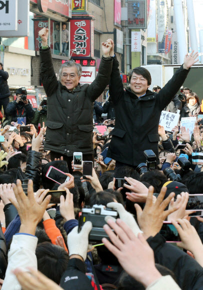 민주통합당 문재인 대선후보와 안철수 전 대선후보가 13일 오후 대전 으능정이 문화거리에서 열린 공동유세에서 환호하는 시민들에게 답례하고 있다. 연합뉴스