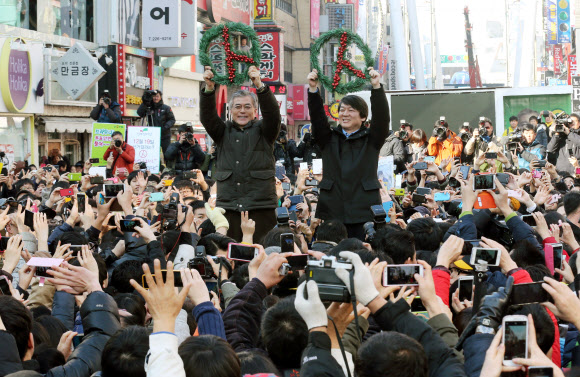 민주통합당 문재인 대선후보와 안철수 전 대선후보가 13일 오후 대전 으능정이 문화거리에서 열린 공동유세에서 환호하는 시민들에게 투표를 당부하고 있다. 연합뉴스