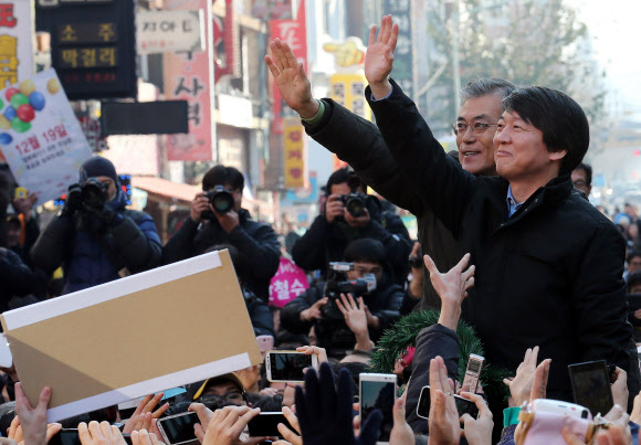 민주통합당 문재인 대선후보와 무소속 안철수 전 후보가 13일 오후 대전 으능정이 문화거리에서 열린 공동유세에서 시민과 지지자들을 향해 손을 들어 인사하고 있다.  문 후보 측은 이번 지방 유세를 통해 안철수 전 후보의 전폭적 지원 선언 이후 시작된 지지율 상승세를 계속해서 이어간다는 계획이다. 연합뉴스