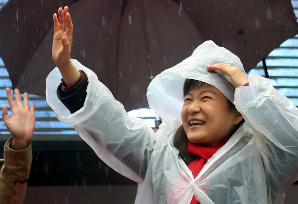 새누리당 박근혜 대선후보가 비가 내린 14일 오전 진주시 장대동 중앙시장 유세에서 연설을 마친 뒤 진주 유권자들을 향해 손을 흔들고 있다.  연합뉴스