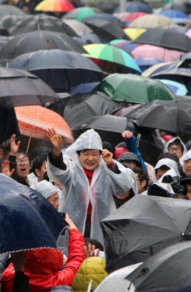새누리당 박근혜 대선후보가 비가 내린 14일 오전 진주시 장대동 중앙시장 유세에서 진주 유권자들을 향해 손을 흔들고 있다.  연합뉴스