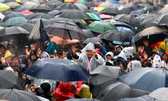 새누리당 박근혜 대선후보가 비가 내린 14일 오전 진주시 장대동 중앙시장 유세에서 진주 유권자들을 향해 손을 흔들고 있다.  연합뉴스