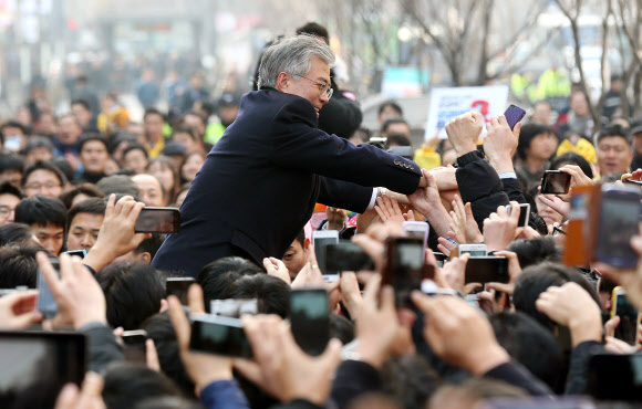 민주통합당 문재인 대선후보가 17일 서울 여의도역 앞에서 열린 유세에서 환호하는 시민들에게 인사를 하고 있다. 연합뉴스