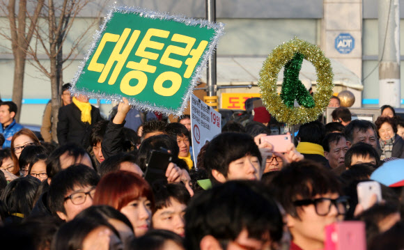 민주통합당 문재인 대선후보가 17일 오후 김포 사우문화체육광장에서 열린 유세에서 시민들에게 지지를 호소하는 가운데 많은 한 시민이 대통령을 바라는 대형 포스터를 들어보이고 있다. 연합뉴스