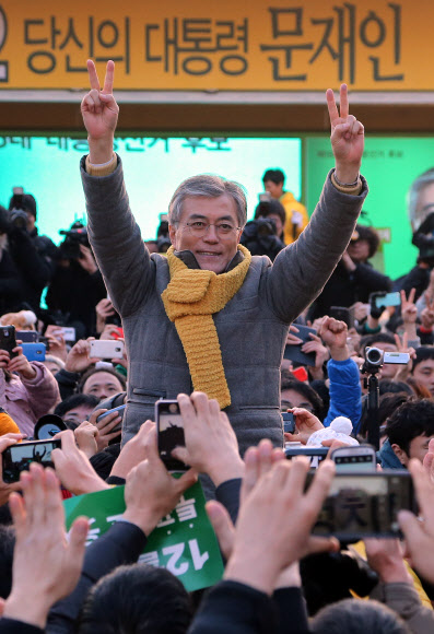 민주통합당 문재인 대선후보가 17일 오후 파주 교하중앙공원에서 열린 유세에서 손을 들어 인사하고 있다. 연합뉴스
