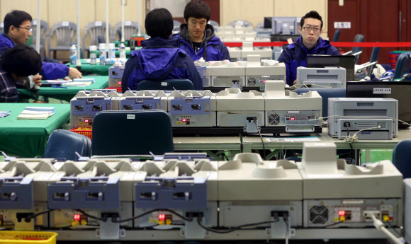 제18대 대선을 하루 앞둔 18일 오후 서울 동대문구청에 마련된 개표소에서 선관위 관계자들이 투표지 분류기를 점검하고 있다. 투표는 19일 오전 6시부터 오후 6시까지 전국 1만3천542곳의 투표소에서 실시된다.  연합뉴스