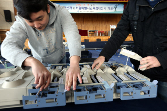 제18대 대통령선거를 하루 앞둔 18일 오전 서울 용산구 이태원초등학교에 마련된 용산구 개표소에서 선관위 관계자들이 개표 장비를 살펴보고 있다.  연합뉴스