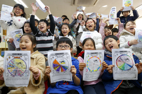 서울시내 초중고등학교 겨울방학이 시작된 18일 서울 중랑구 서울원묵초등학교 2학년 학생들이 방학식을 마친 뒤  생활계획표를 들고 즐거워하고 있다. 연합뉴스