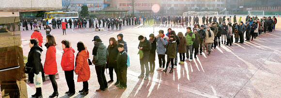 뜨거운 한표   서울 은평구 응암1동 신진자동차고등학교에 마련된 응암 제6투표소에서 소중한 한 표를 행사하러 나온 유권자들이 추운 날씨에도 아랑곳 없이 길게 줄지어 서서 차례를 기다리고 있다.