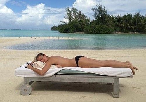 모델 하이디 클룸이 한 해변에서 반라의 상태로 침대에 누워 망중한을 즐기고 있다.<br>하이디 클룸 트위터