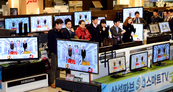 18대 대통령 선거가 치러진 지난 19일 서울 용산구 한강로 아이파크몰 가전 매장에서 시민들이 방송사들의 출구조사 결과 발표를 지켜보고 있다. 이언탁기자 utl@seoul.co.kr