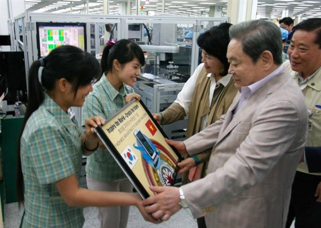 지난 10월 베트남의 삼성전자 휴대전화 공장을 방문한 이건희 삼성전자 회장이 현지 직원들에게 휴대전화 누적생산 20억대 기념패를 받고 있다. 삼성전자는 베트남 옌퐁에 휴대전화 연산 1억 5000만대 규모의 공장을 운영 중이다.  삼성전자 제공