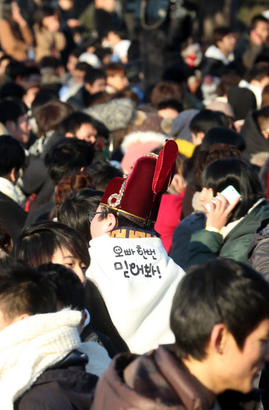 크리스마스 이브인 24일 오후 서울 여의도 공원에서 열린 소셜이벤트 ‘솔로대첩’에서 한 참가자가 익살스런 문구가 적힌 망토를 두르고 있다. 연합뉴스