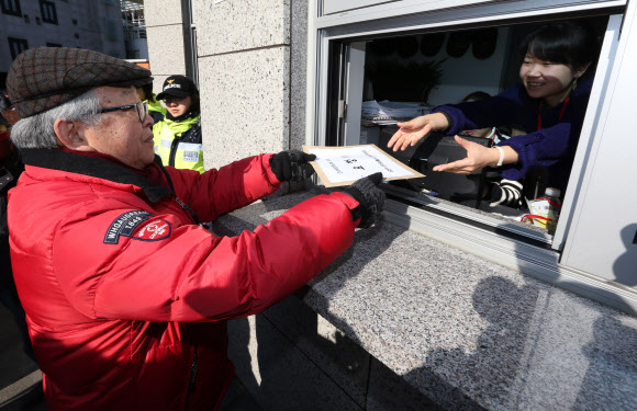 수화언어 권리 확보를 위한 공동대책위원회 소속 농아인들이 18일 오후 서울 종로구 삼청동 대통령직 인수위원회 앞에서 ‘농교육 개선 및 수화언어기본법 제정 요구’ 기자회견을 했다. 한 참석자가 기자회견 뒤 이같은 내용을 담은 요구서를 인수위에 전달하고 있다. 연합뉴스