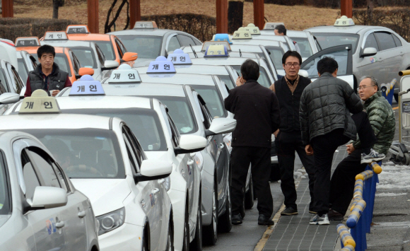 정부가 22일 택시를 대중교통으로 인정하는 내용을 골자로 하는 택시법에 대해 거부권을 행사한 가운데, 서울 김포공항에서 택시들이 줄지어 서서 승객을 기다리고 있다. 정연호 기자 tpgod@seoul.co.kr 