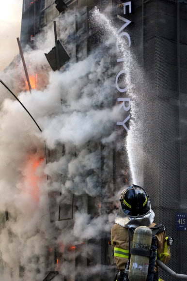 25일 오전 10시39분께 서울 강남구 삼성동에 있는 한 2층짜리 아울렛 의류매장 건물에서 화재가 발생해 소방대원들이 진화작업을 벌이고 있다. 연합뉴스
