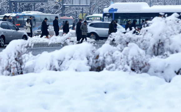 서울에 16cm의 폭설이 쏟아지는 등 중부지방에 많은 눈이 내린 4일 광화문 거리에서 시민들이  대중교통을 이용해 출근을 하고 있다. 연합뉴스
