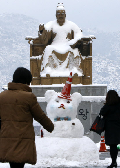 서울에 16cm의 폭설이 쏟아지는 등 중부지방에 많은 눈이 내린 4일 광화문 세종대왕 동상 뒤 북악산이 눈으로 덮여 있다. 연합뉴스