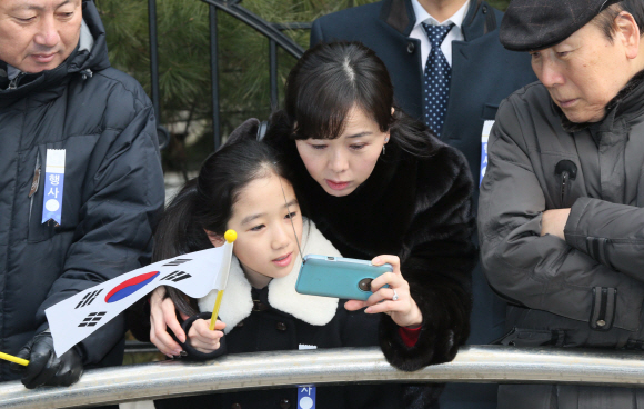 박근혜 대통령의 자택이 있는 서울 강남구 삼성동 주민들이 25일 오전 박 대통령이 취임식에 참석하기 위해 자택을 나서는 장면을 DMB를 통해 보고 있다. 공동취재단