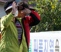 지난해 불산가스가 누출된 경북 구미시 산동면 봉산리의 주민들이 마스크를 쓰고 걷는 길 옆에 정부의 대책 마련을 촉구하는 현수막이 내걸려 있다.<br>서울신문 포토라이브러리