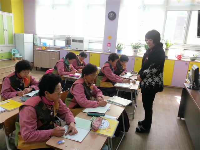 경남 하동군 고전면 고전초등학교에 입학한 7명의 할머니들이 5일 박윤희(오른쪽) 담임 교사의 수업을 받고 있다.