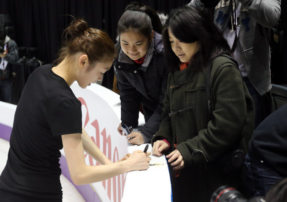 피겨여왕 김연아가 12일(한국시각) 2013 국제빙상경기연맹(ISU) 세계피겨선수권대회가 열리는 캐나다 온타리오주 런던 버드와이저 가든스에서 첫 공식훈련을 마치고 팬들에게 사인을 해주고 있다.  연합뉴스