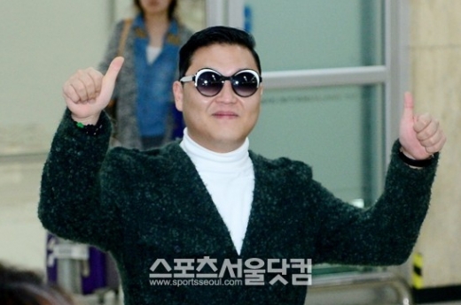 신곡 발표와 대규모 단독 콘서트를 앞둔 가수 싸이가 17일 오전 김포국제공항을 통해 귀국한 가운데 팬에게 포즈를 취하고 있다.