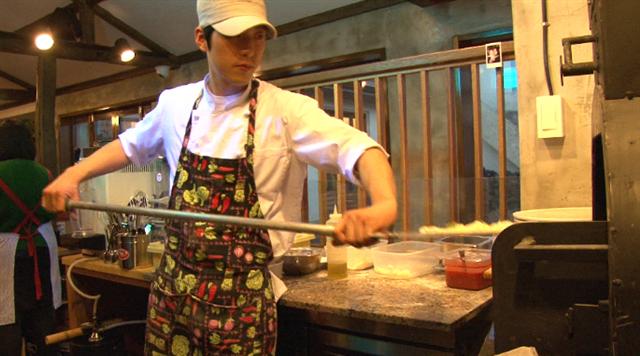 남편인 박윤진씨가 손님에게 개방된 주방의 화덕 앞에서 피자를 굽고 있다. 제주 대평리에 자리한 박씨 부부의 레스토랑은 맛과 여유를 함께 제공하는 곳이다. KBS 제공