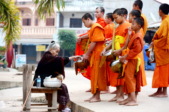 방비엥의 한 주민이 탁밧(탁발의 라오스말)에 나선 어린 승려에게 밥을 나눠 주고 있다. 동틀 무렵 펼쳐지는 이 같은 탁밧 행렬은 라오스 어디서든 흔히 볼 수 있는 풍경이다.