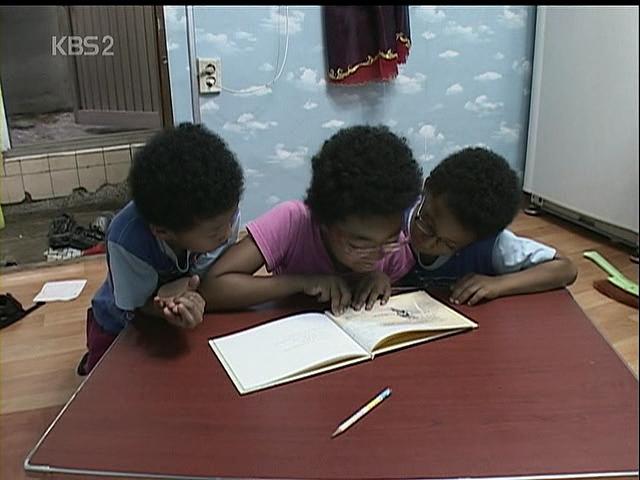 2008년 방송된 KBS 다큐멘터리 ‘인간극장’의 한 장면. 아버지가 일하러 간 뒤 함께 책을 읽는 삼 남매의 모습이 정겹다. KBS 제공