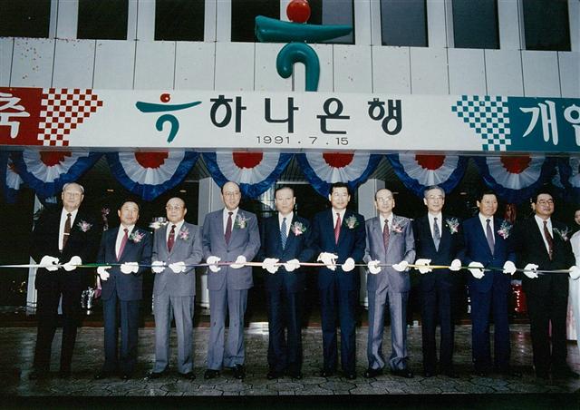 1991년 7월 윤병철(왼쪽 여섯번째) 회장이 하나은행 초대은행장으로 선임된 뒤 기념 테이프를 자르고 있다.