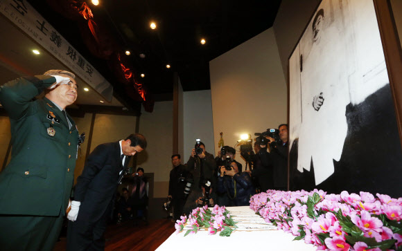 26일 오전 서울 안중근의사기념관에서 열린 ‘안중근의사 순국 103주기 추모식’에서 한 참석자가 헌화한 후 경례하고 있다.  연합뉴스